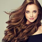 a headshot of a brunette woman using luxury Russian hair extensions