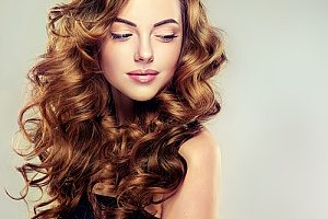 a woman with curly Russian hair extensions to match her ideal appearance